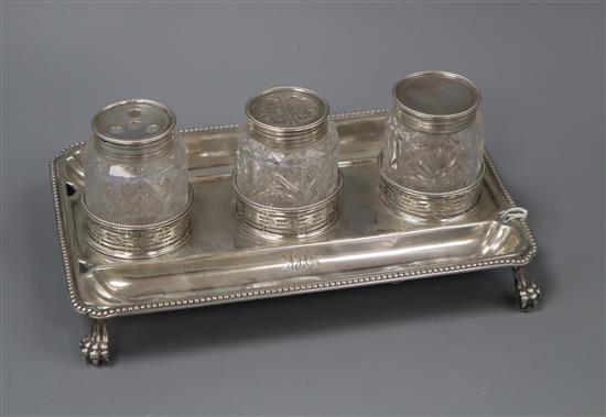 A George III silver rectangular inkstand, London, 1779, with three associated? mounted glass wells (unmarked), 25cm.